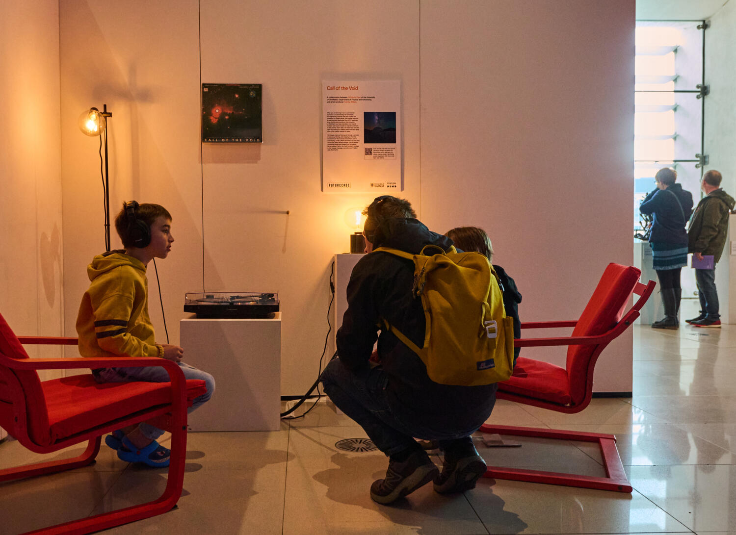 Visitors to the exhibit listen to the album on headphones as it plays on a record player.